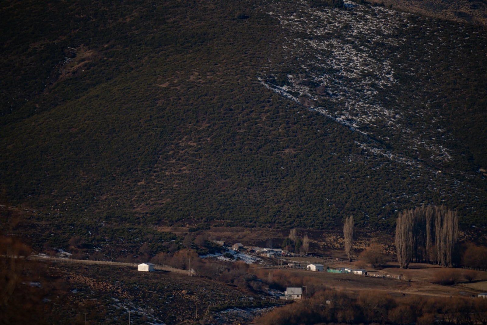 Valle con caserío y cordillera nevada